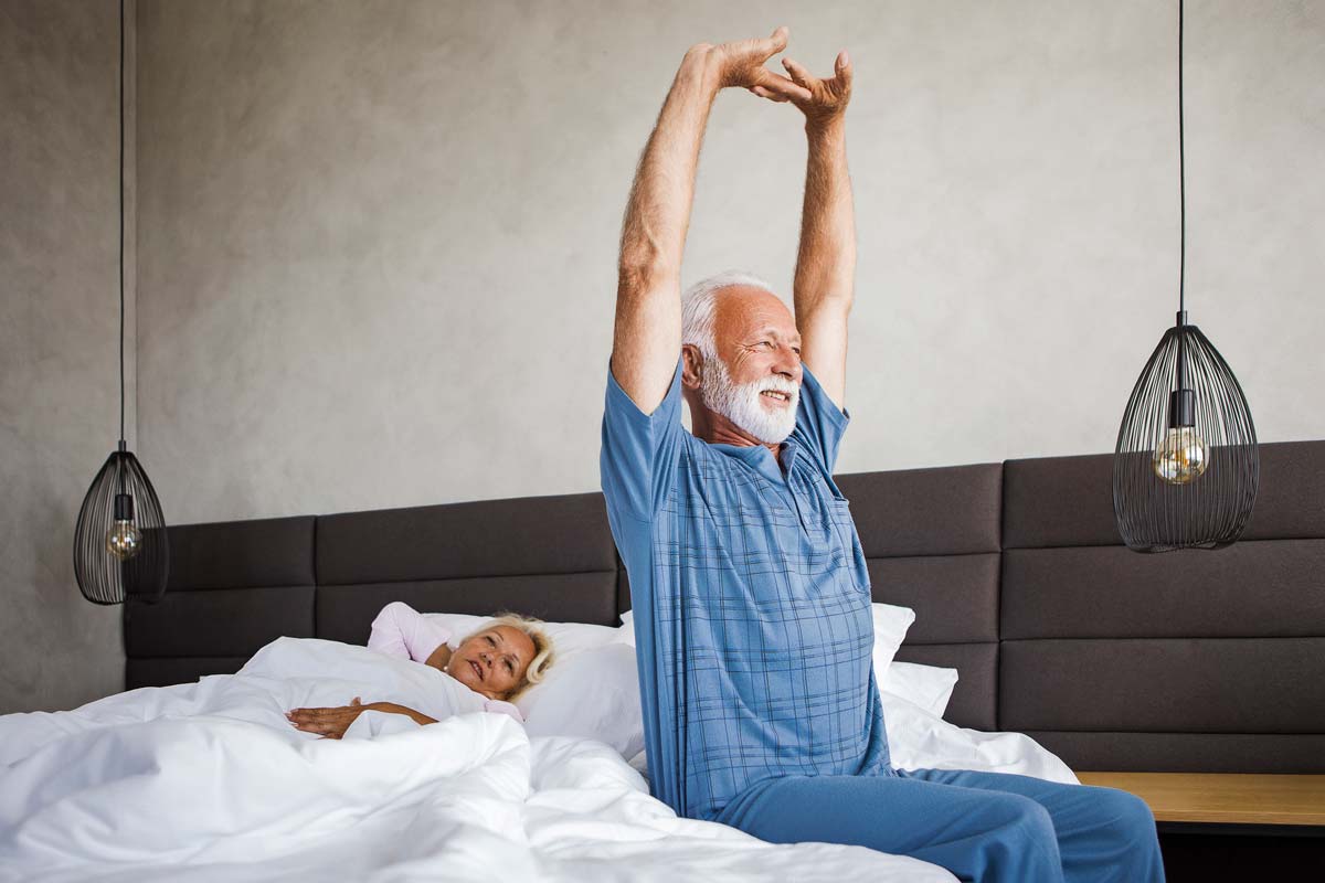 Man stretching in bed in the morining