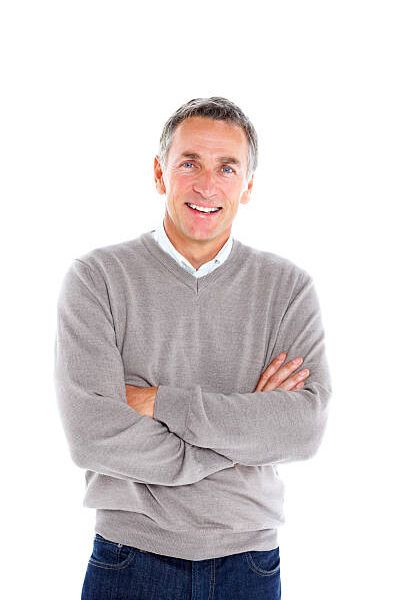 Portrait of cheerful mature man standing with his arms crossed on white background